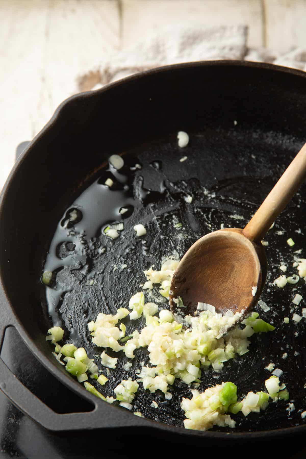 Garlic, ginger and scallions cooking in a skillet.