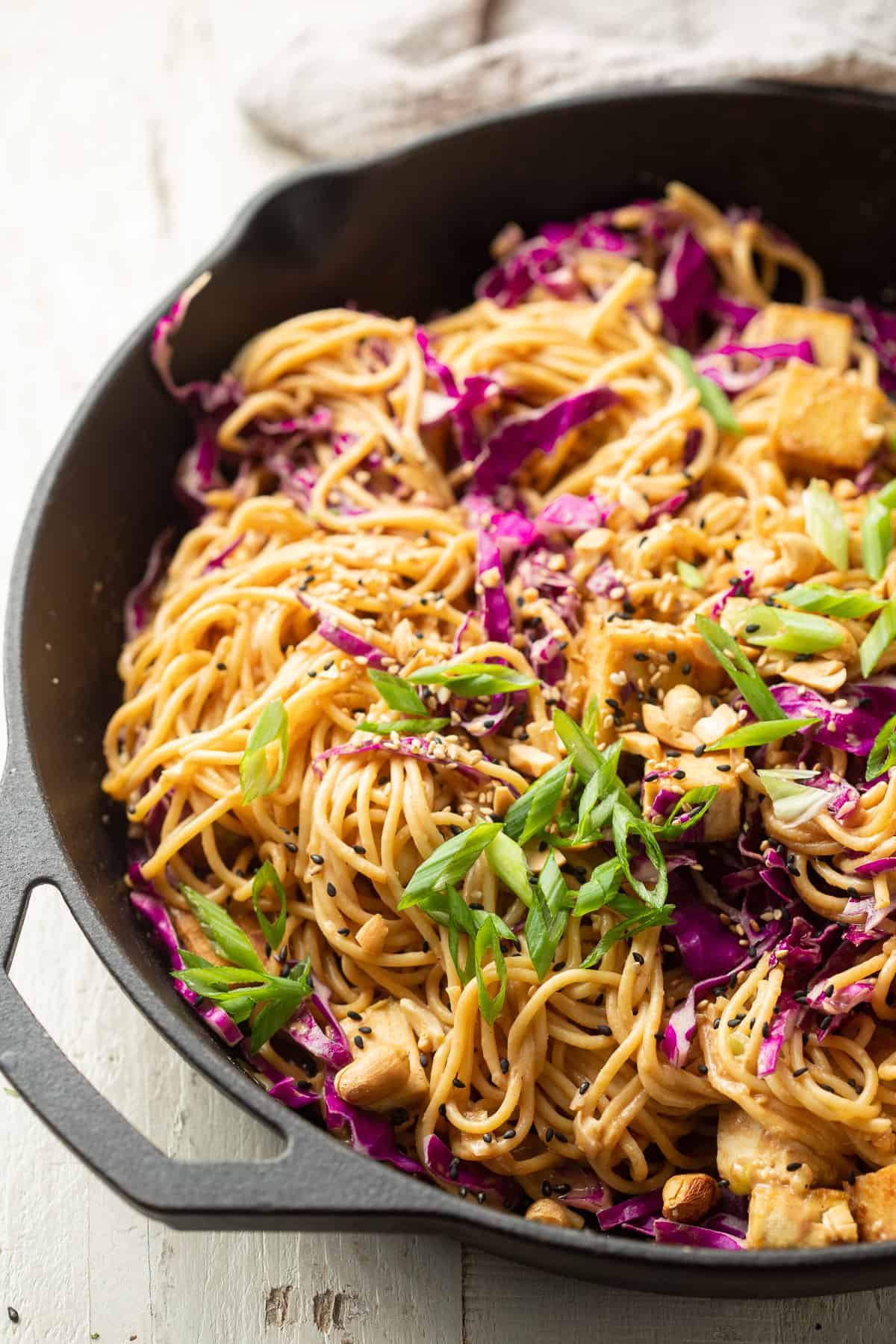 Close up of Sesame Peanut Noodles in a cast iron skillet.