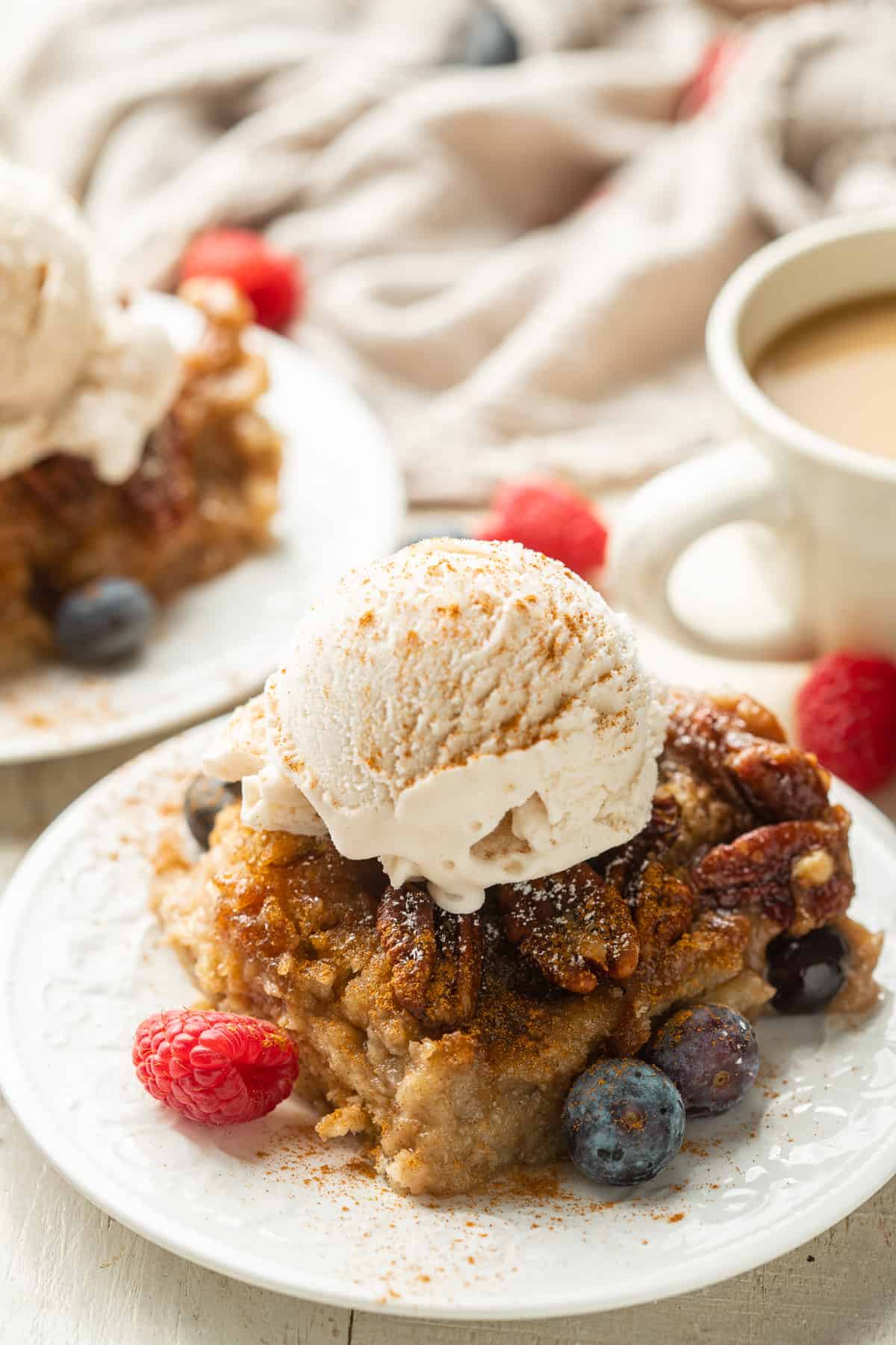 Slice of Vegan Bread Pudding on a plate with a scoop of ice cream on top.