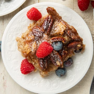 Slice of Vegan Bread Pudding on a plate with berries.