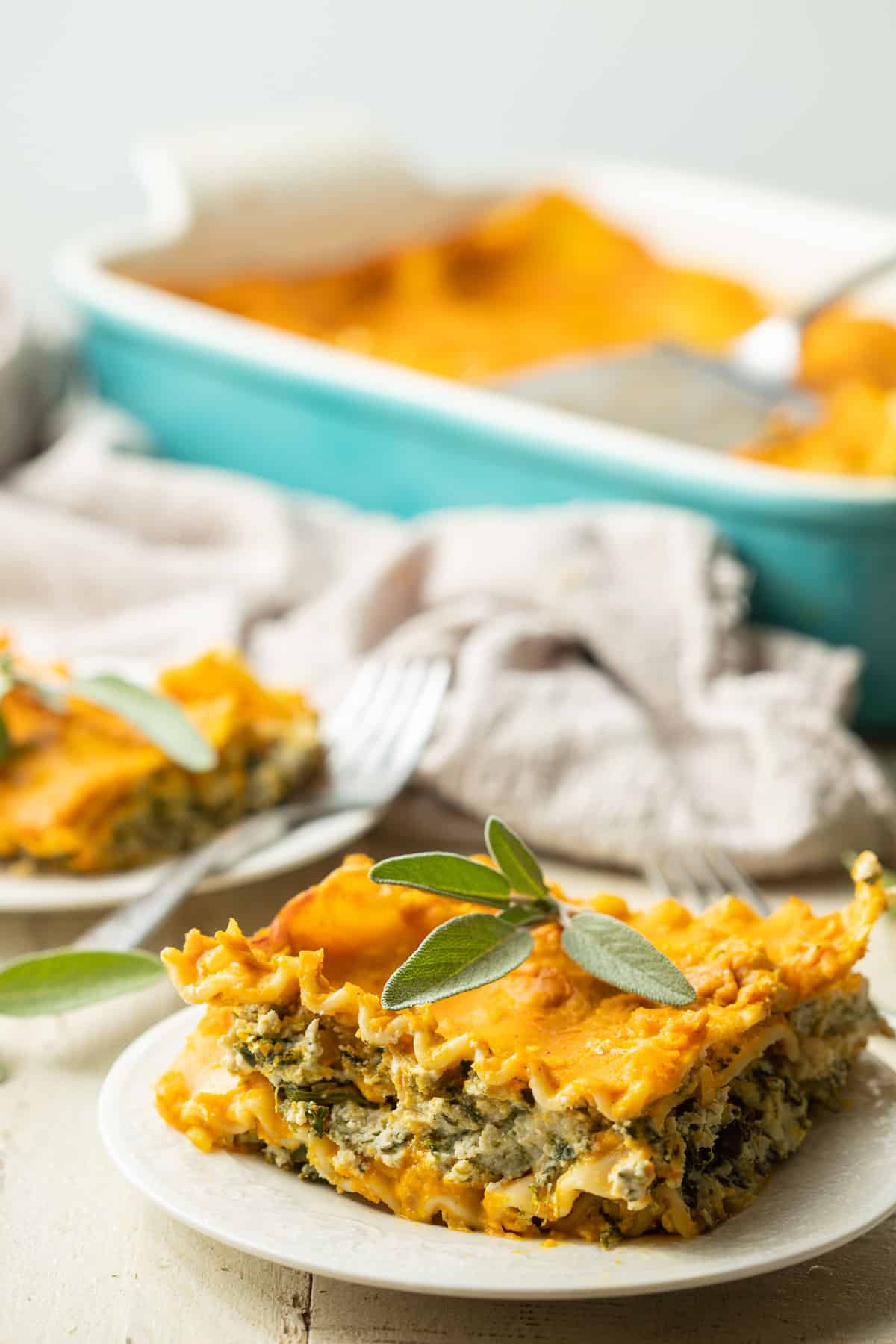 Slice of Vegan Pumpkin Lasagna on a plate with baking dish in the background.