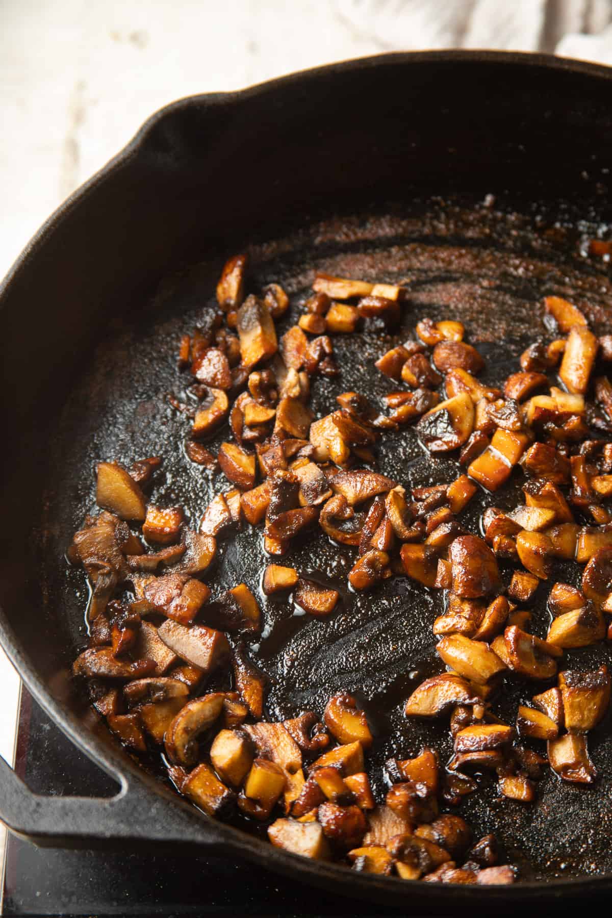 Mushroom bacon cooking in a skillet.