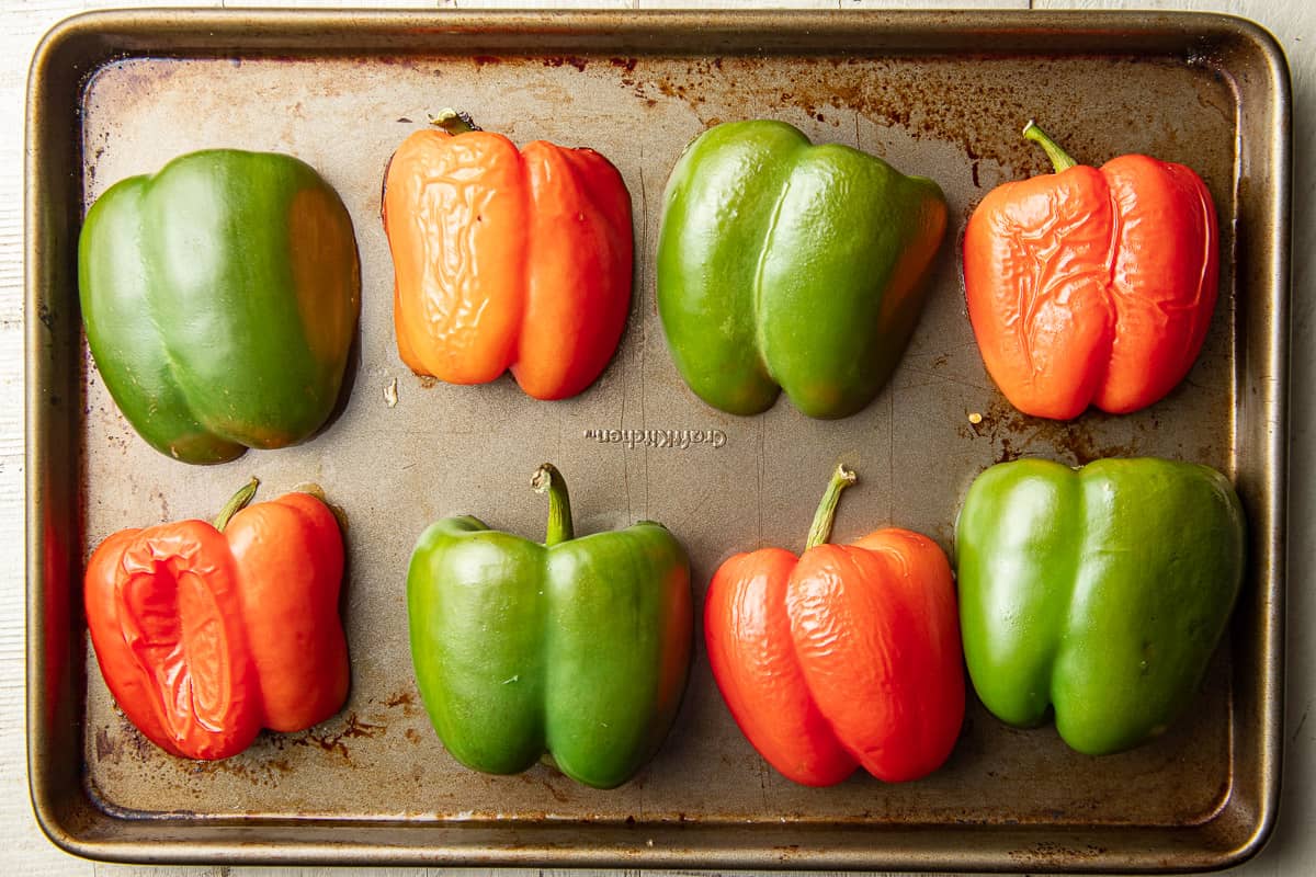 Roasted bell pepper halves on a baking sheet.