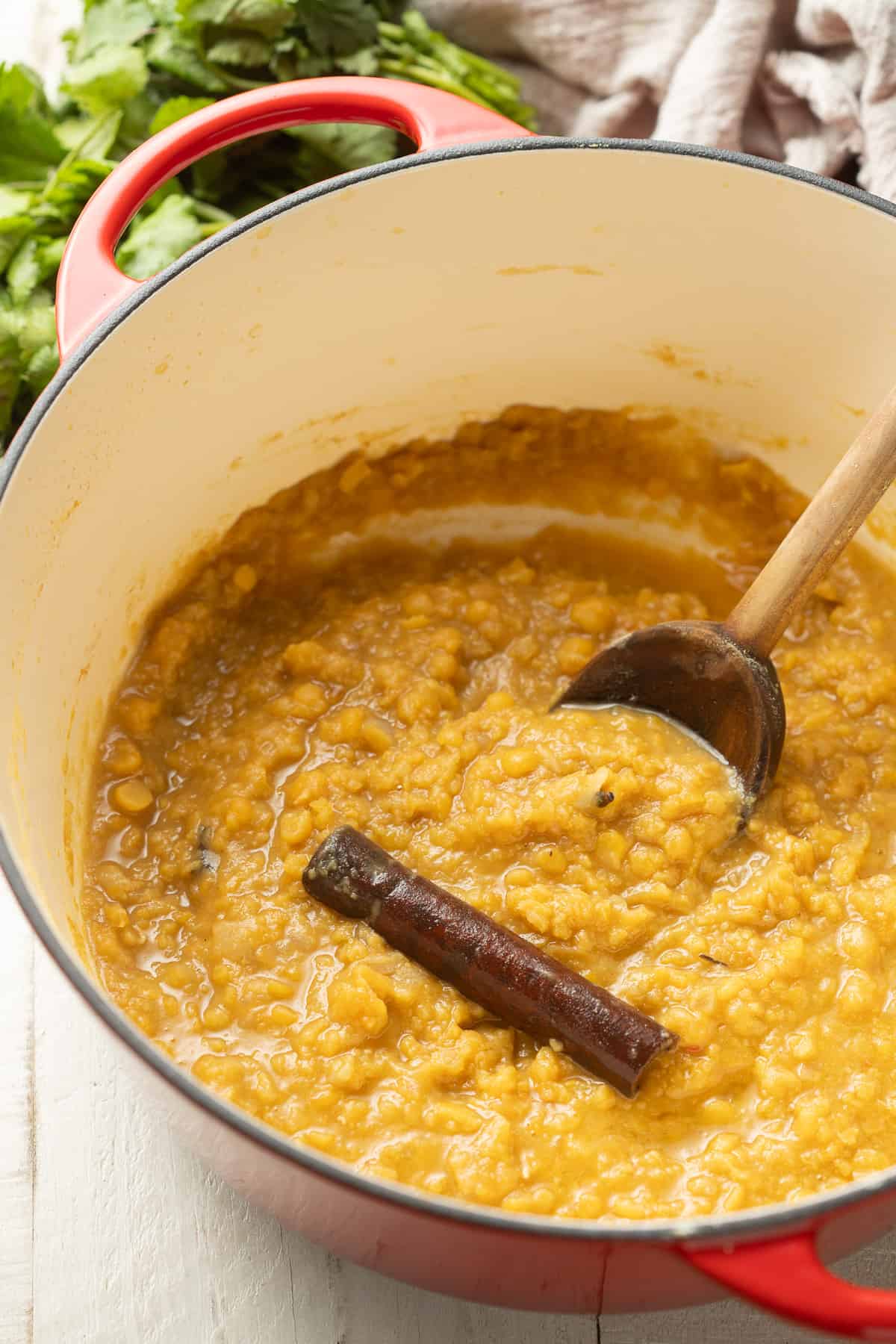Pot of Yellow Split Pea Dal with a cinnamon stick in it.