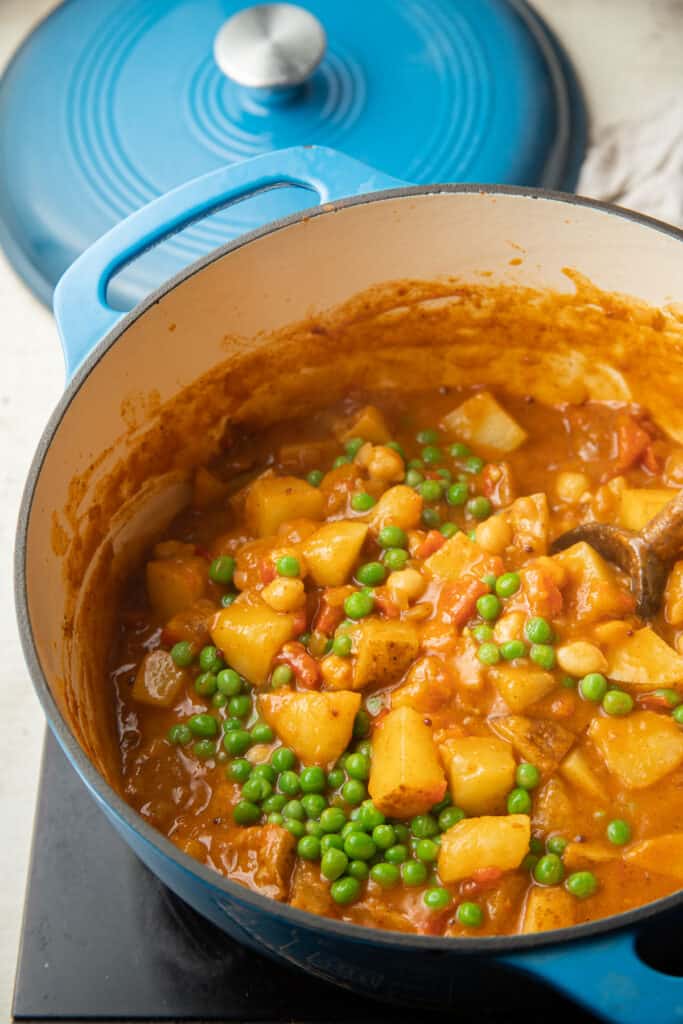 Pot of Potato Curry with peas simmering on the stove.