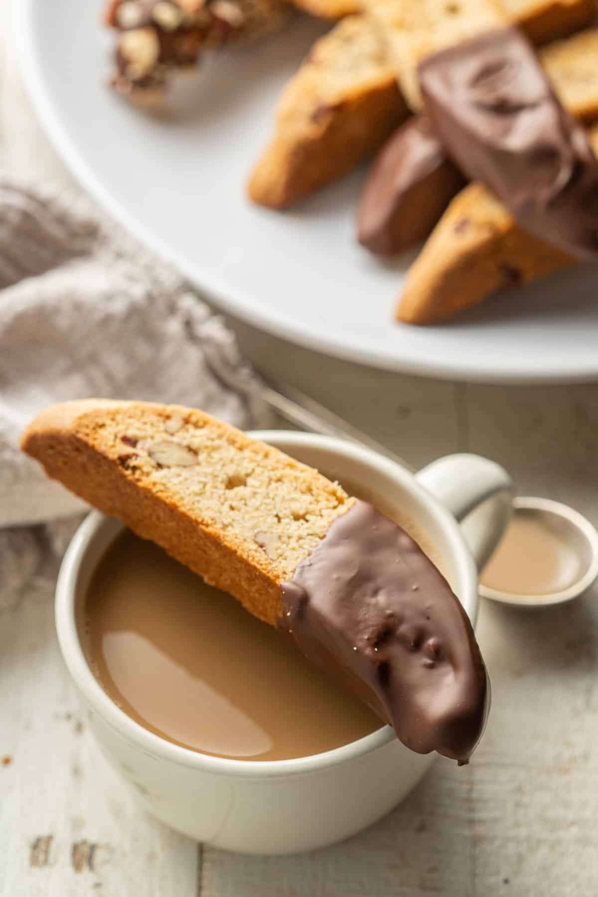 Chocolate dipped Vegan Biscotti sitting on top of a coffee cup.