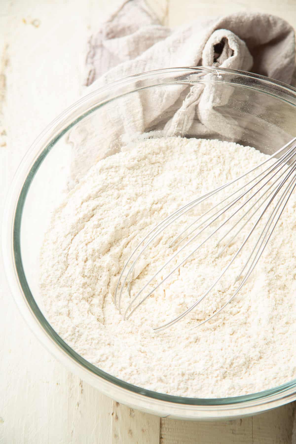 Dry ingredients for cake in a mixing bowl with whisk.