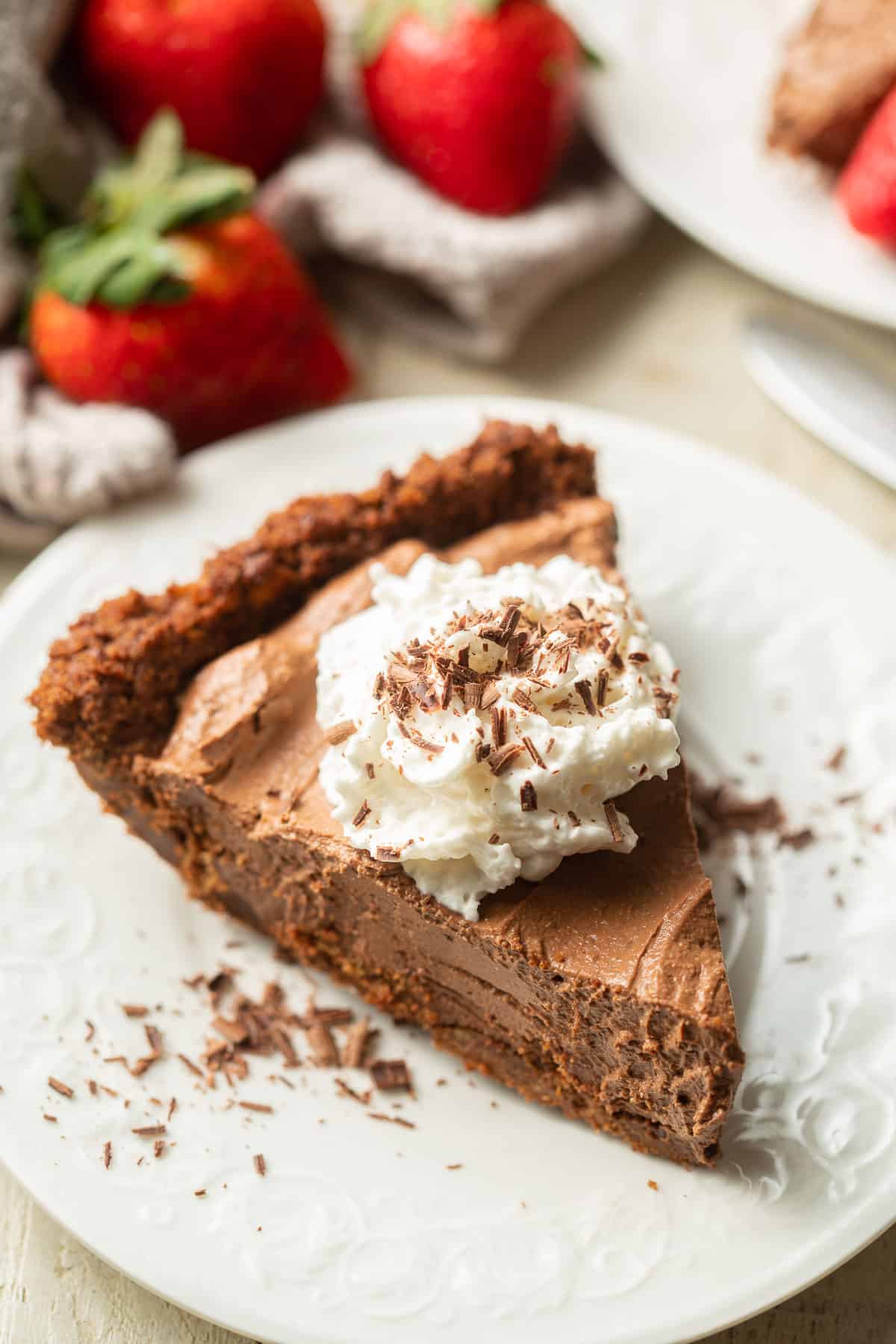Slice of Vegan Chocolate Pie on a plate with whipped cream and chocolate shavings on top.