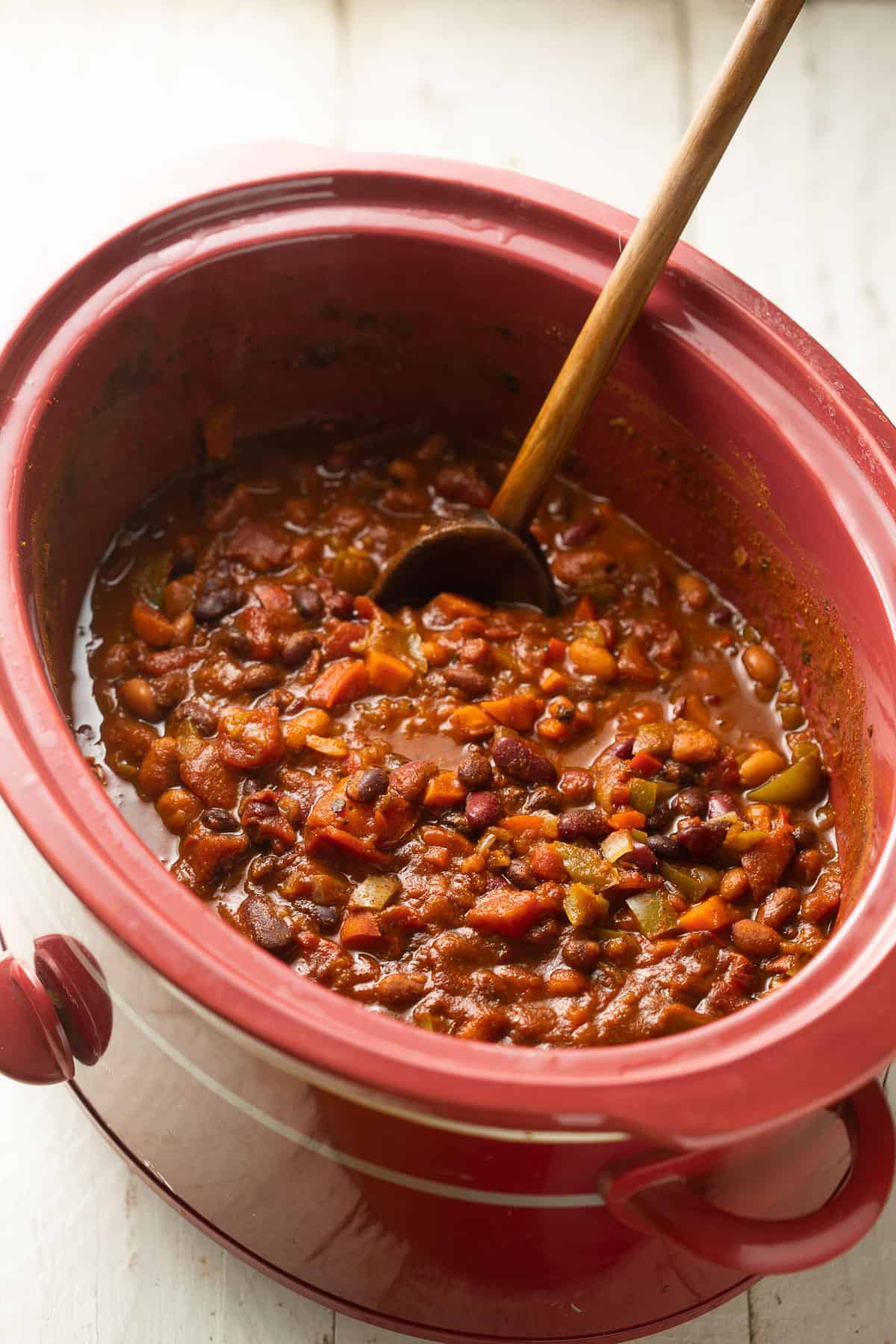 Vegan chili in a crockpot with wooden spoon.