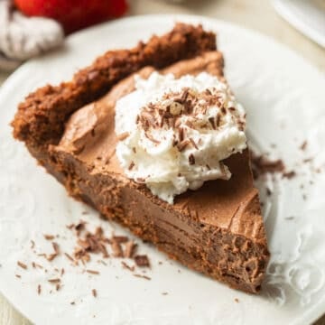 Slice of Vegan Chocolate Pie with whipped cream and chocolate shavings on top.