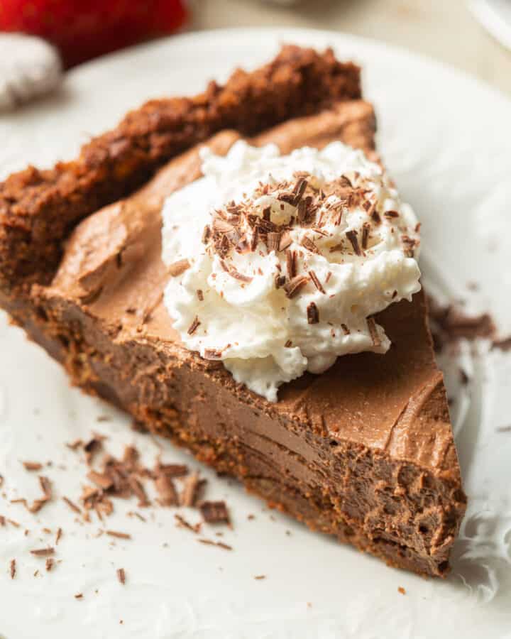 Slice of Vegan Chocolate Pie with whipped cream and chocolate shavings on top.