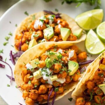 Chickpea Tacos on a plate with limes and cilantro in the background.