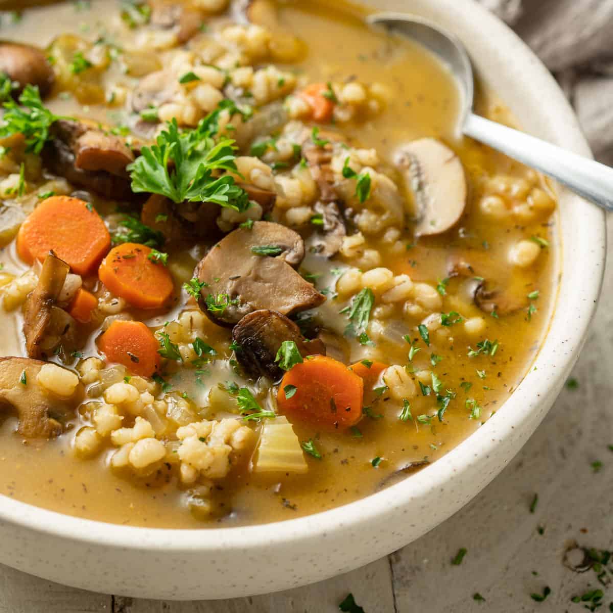 Close up of Mushroom Barley Soup in a bowl with spoon.