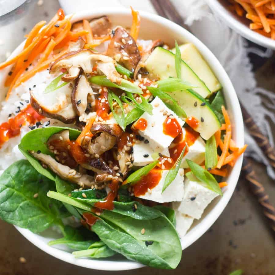 Close up of a bowl of vegan bibimbap with chopsticks on the side.