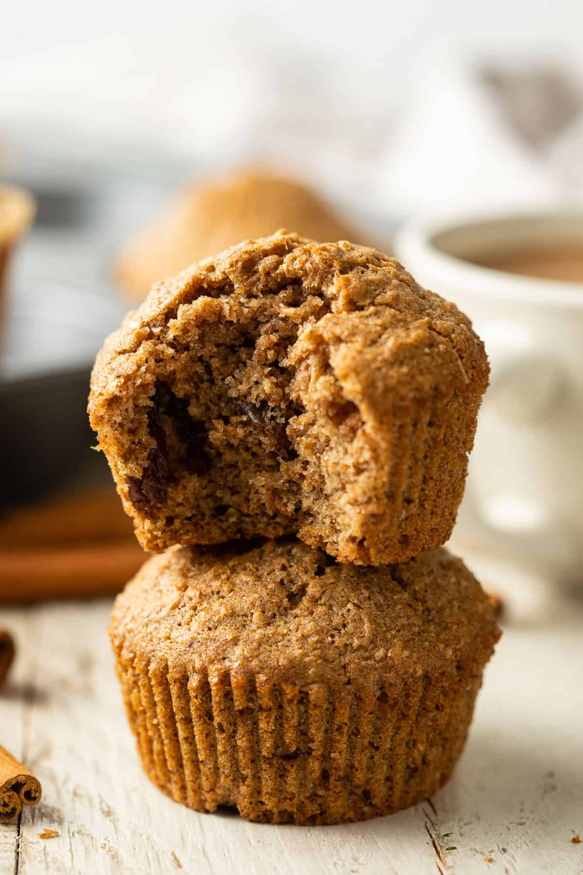 Two stacked Vegan Bran Muffins, the top one with a bite taken out.