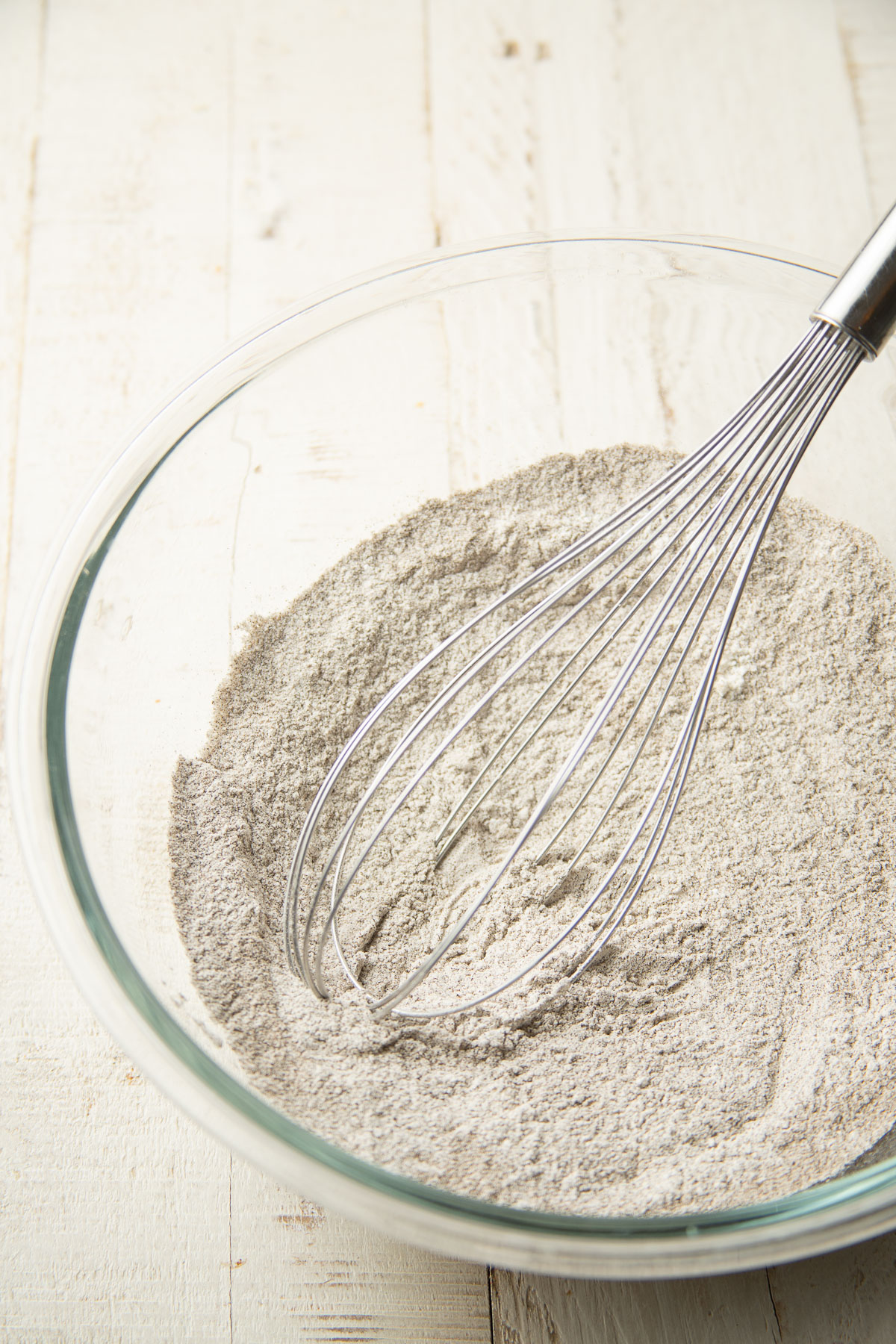 Dry ingredients for buckwheat pancake batter in a mixing bowl with whisk.