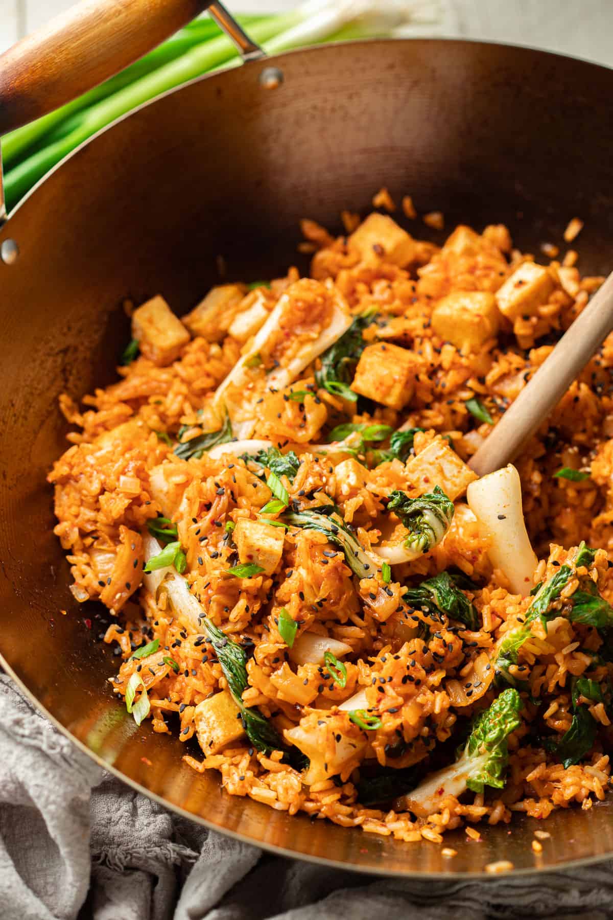 Vegan Kimchi Fried Rice in a wok with wooden spoon.