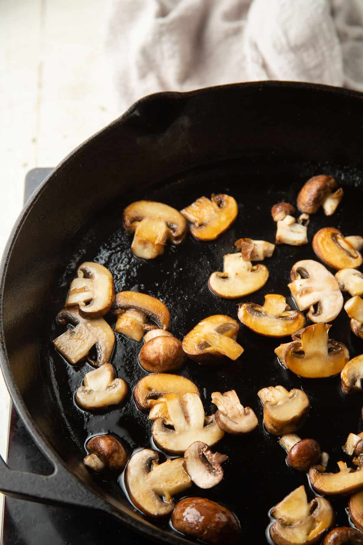 Mushrooms cooking in a skillet.
