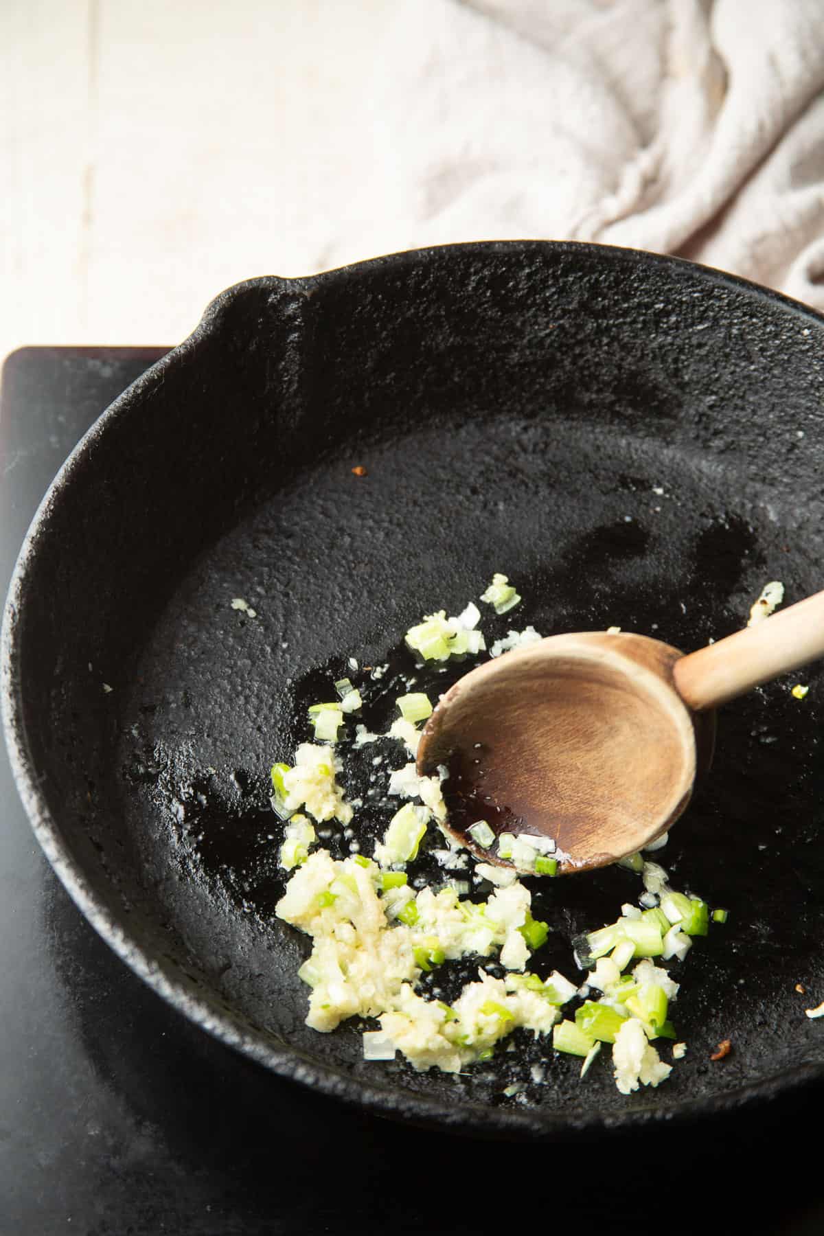 Cook garlic, ginger and scallions in a pan.