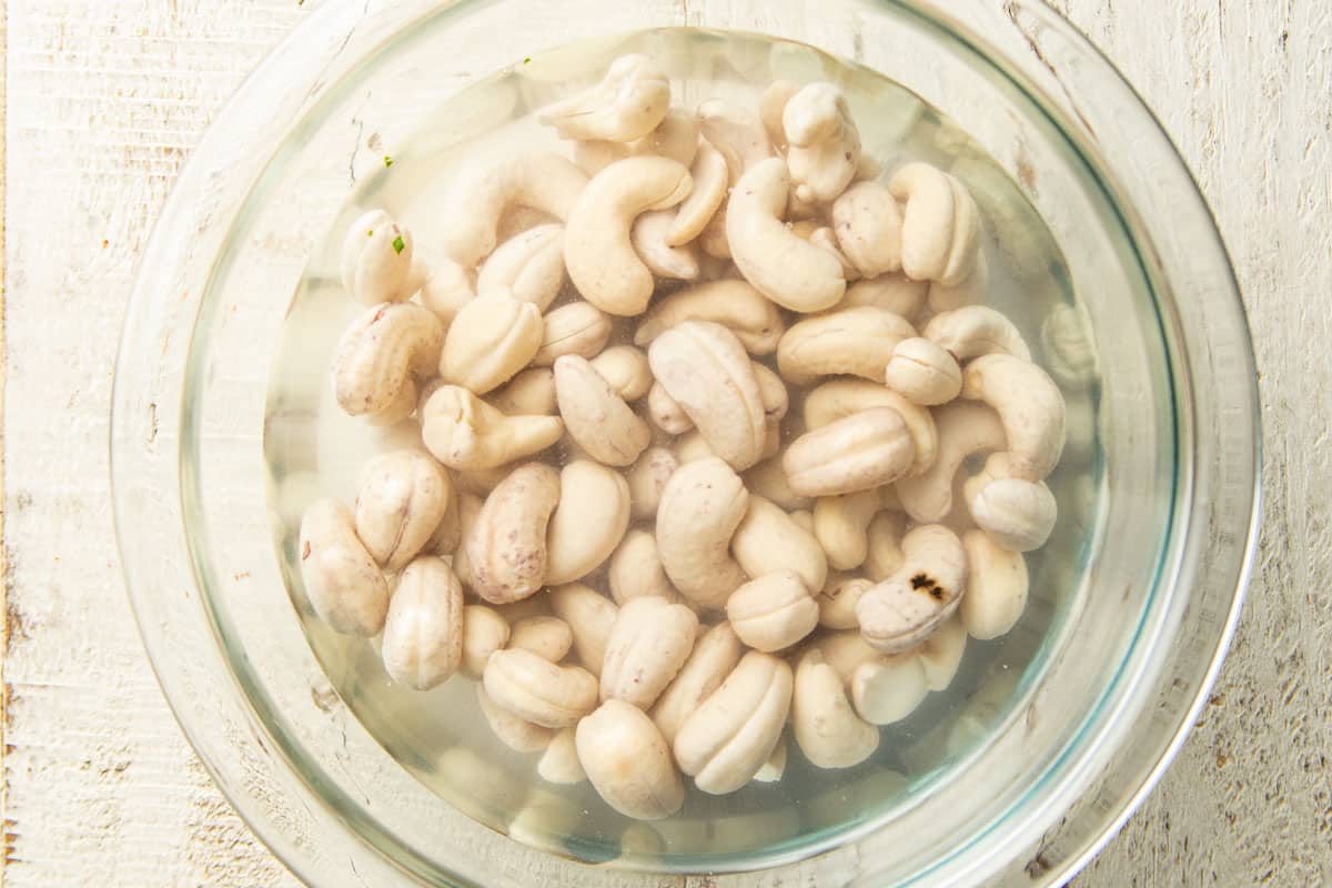 Cashews soaking in a bowl of water.