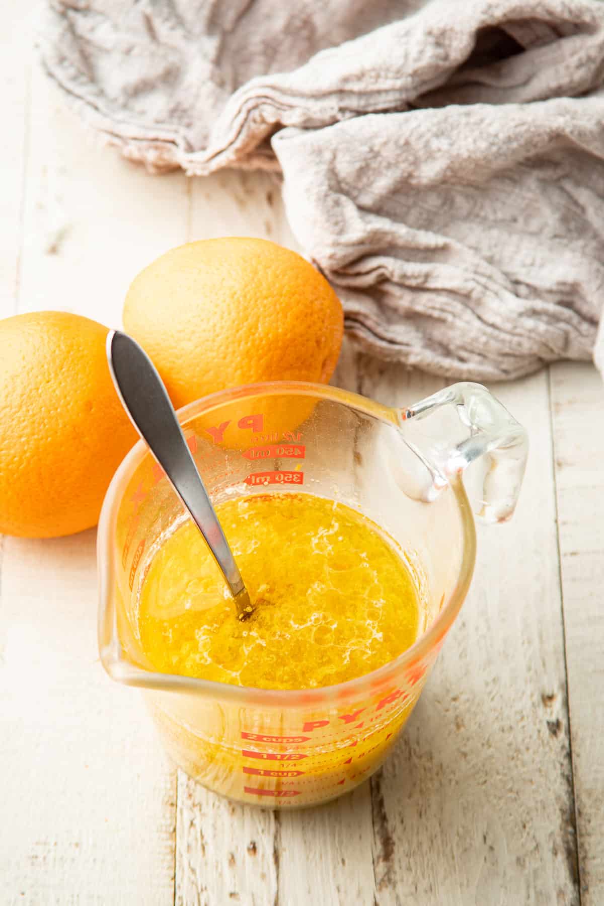 Measuring cup with liquid ingredients for orange cake.
