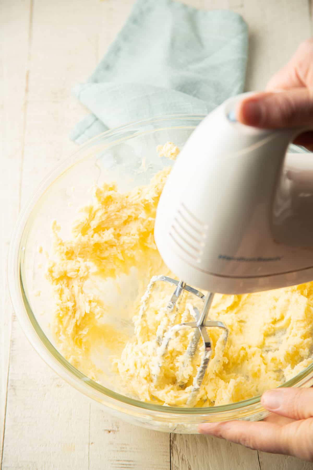 Vegan butter and sugar being beaten together in a mixing bowl.