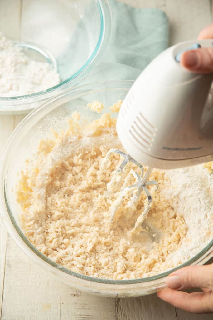 Flour mixture being beaten into butter mixture to make cookie dough.