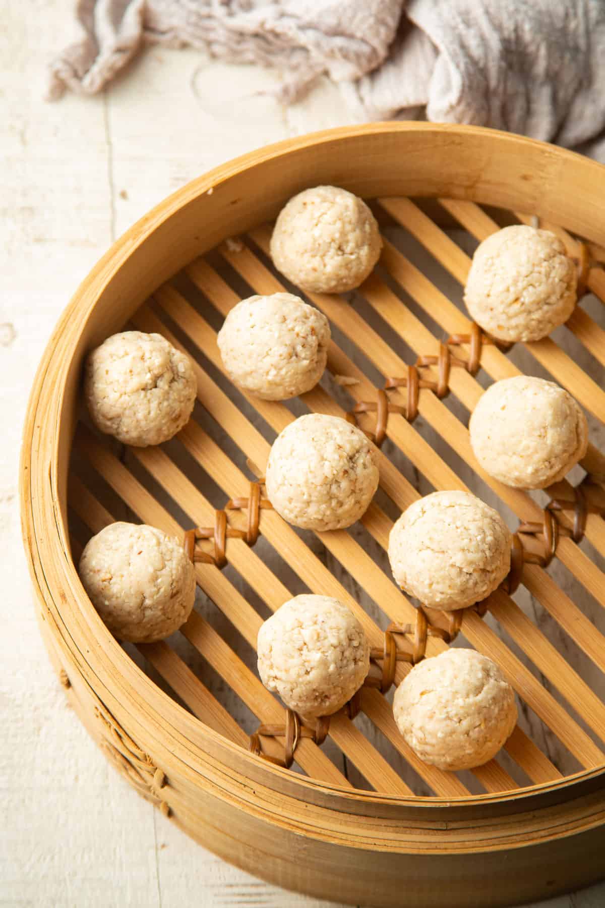 Uncooked vegan matzo balls in a bamboo steamer.