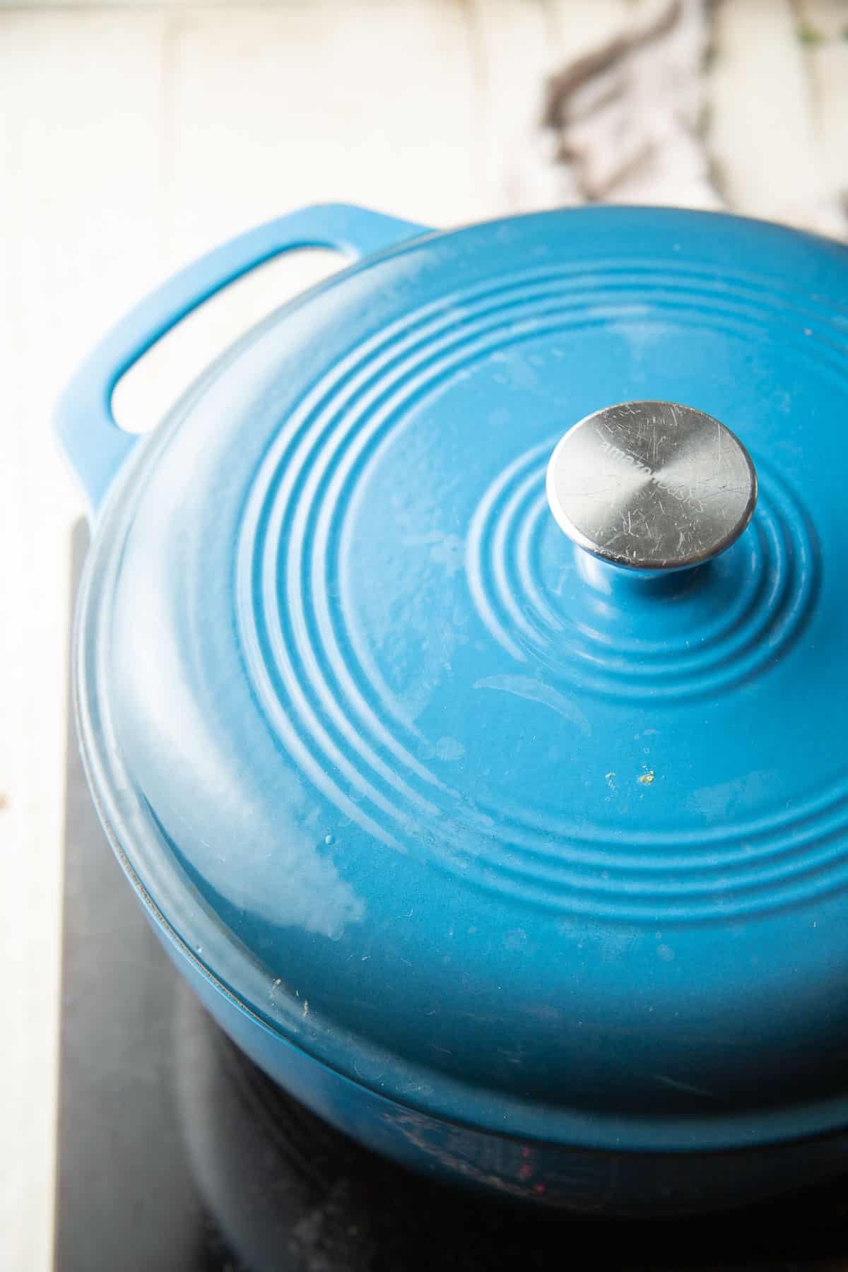 Blue pot with lid is cooking.