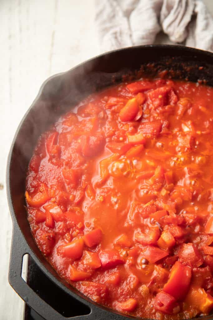 Tomato and pepper sauce simmering in a skillet.