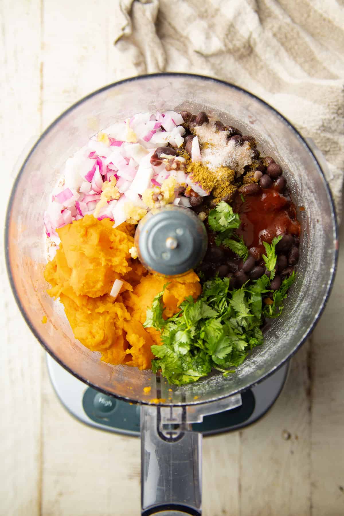 Ingredients for making Sweet Potato Black Bean Burgers in a food processor bowl.