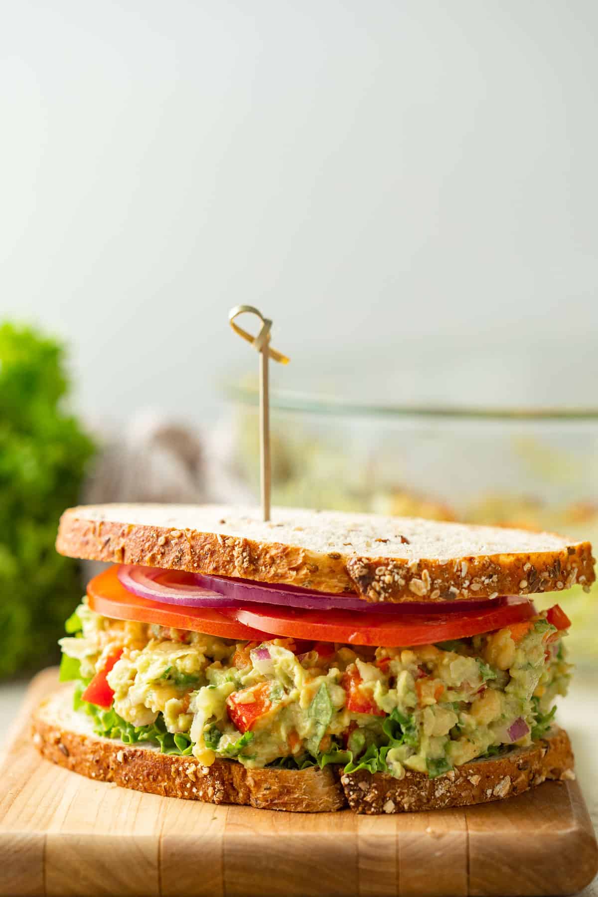 Smashed Chickpea Avocado Sandwich with a skewer through it.