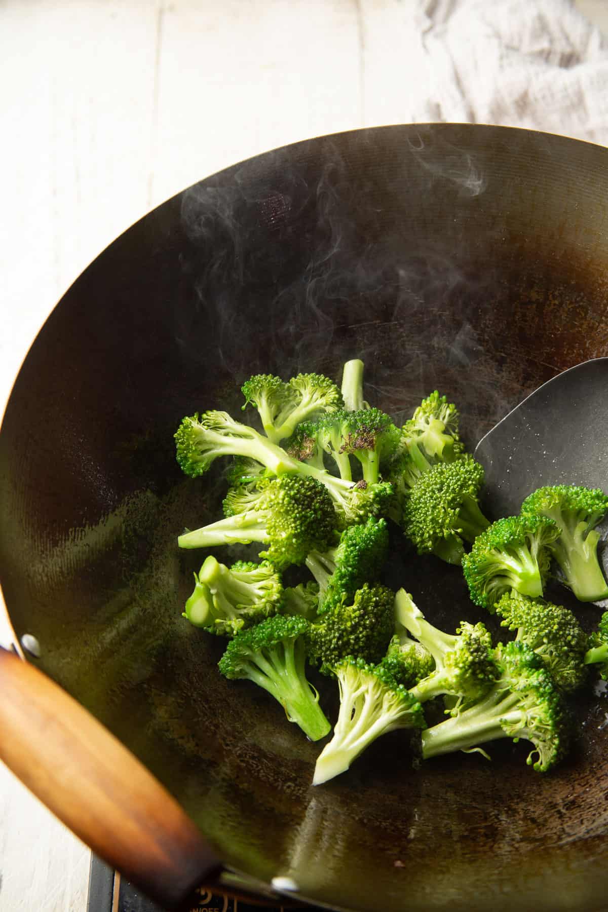 Broccoli stir-frying in a wok.