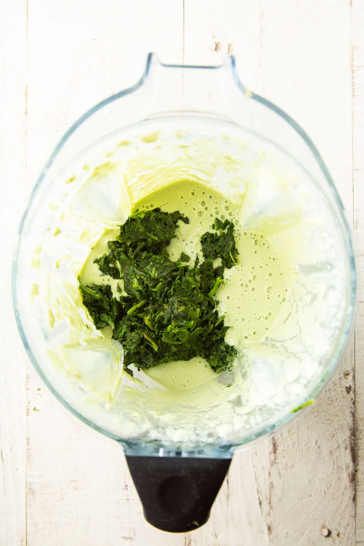 Cashew cream in a blender with spinach.