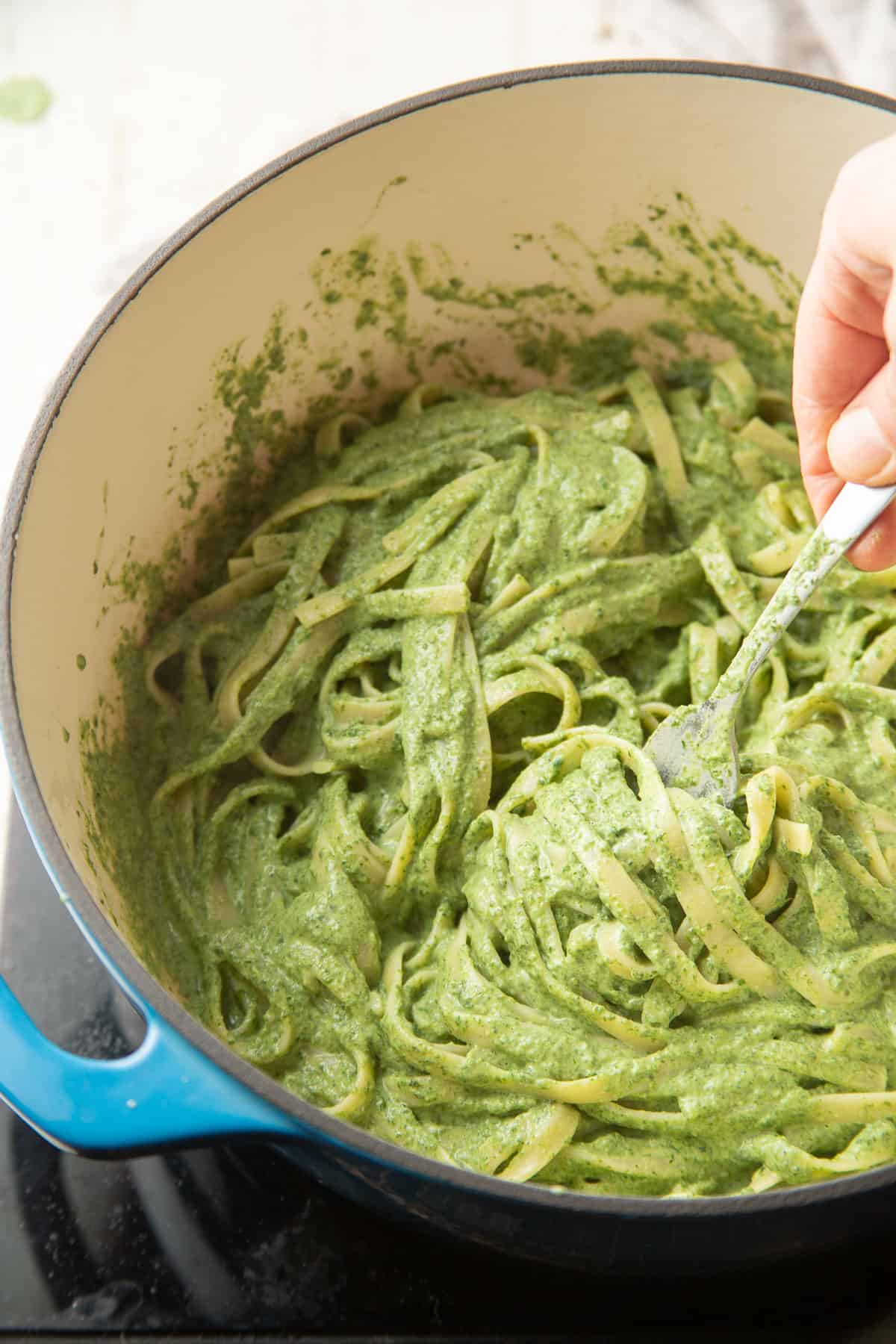 Stir in the vegan spinach pasta in a bowl.