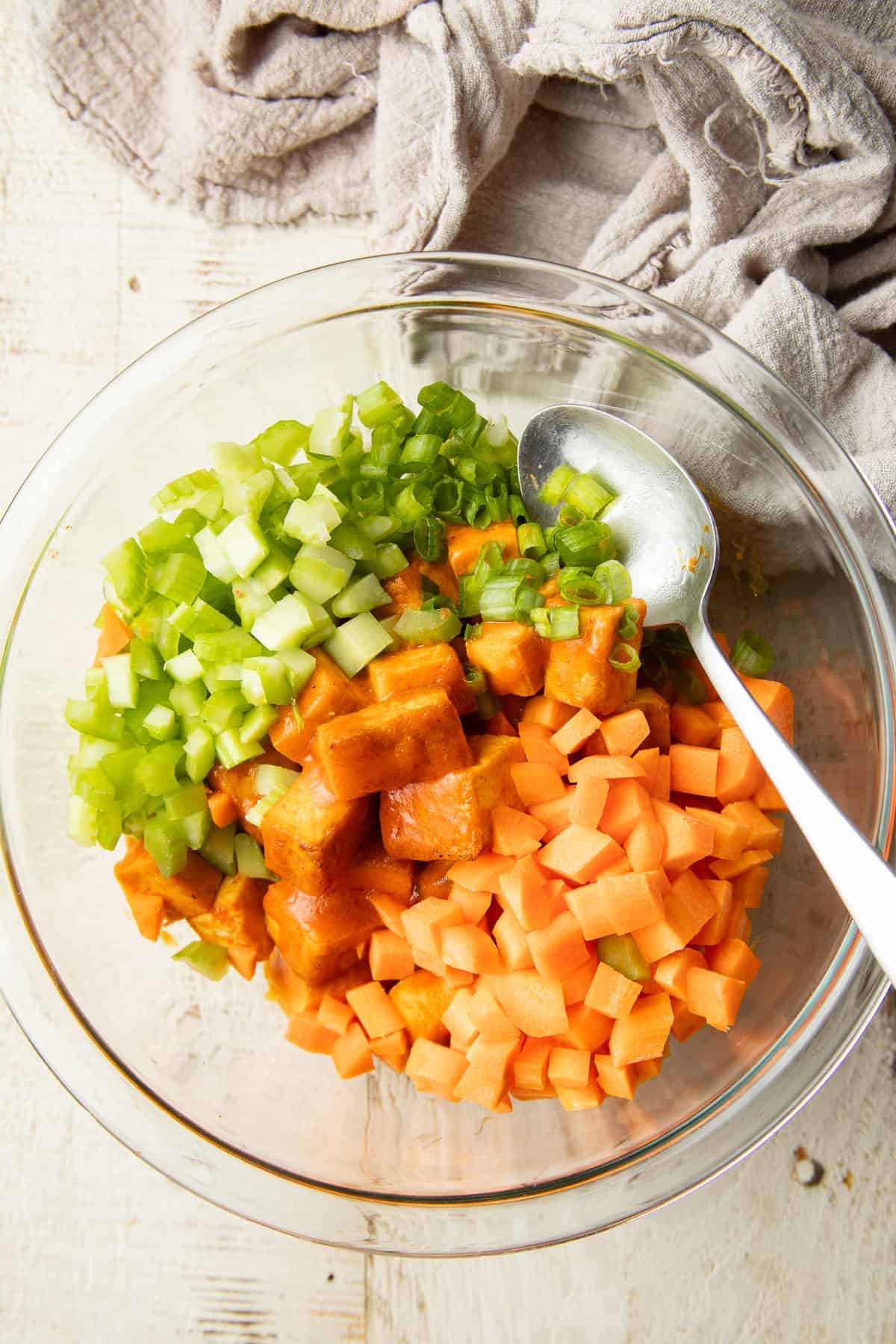 Buffalo tofu, celery and carrots in a bowl with spoon.