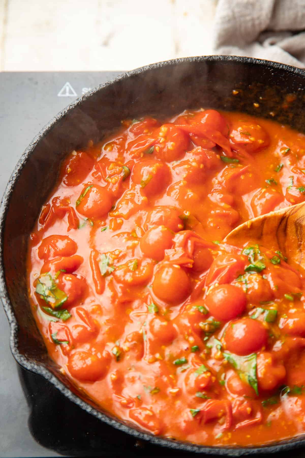 Cherry Tomato sauce simmering in a skillet.