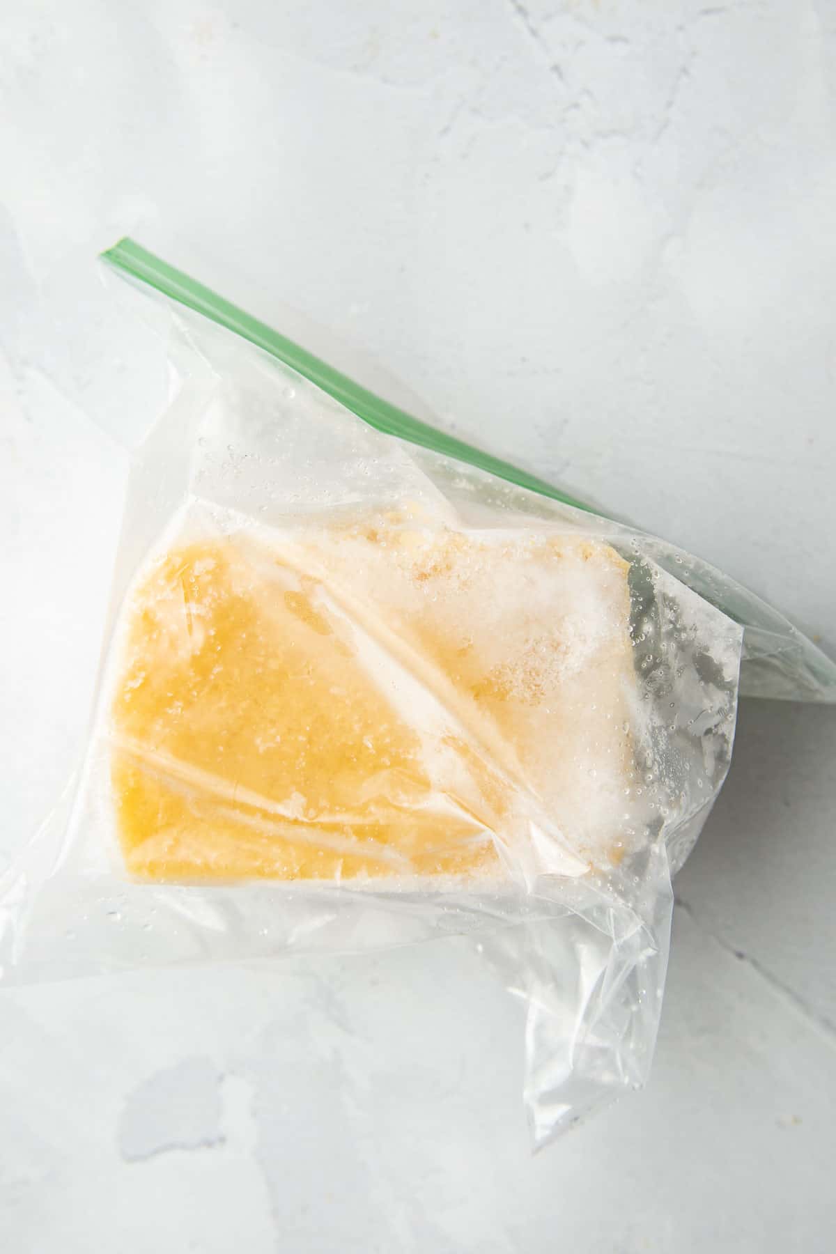 Block of frozen tofu in a zipper bag.