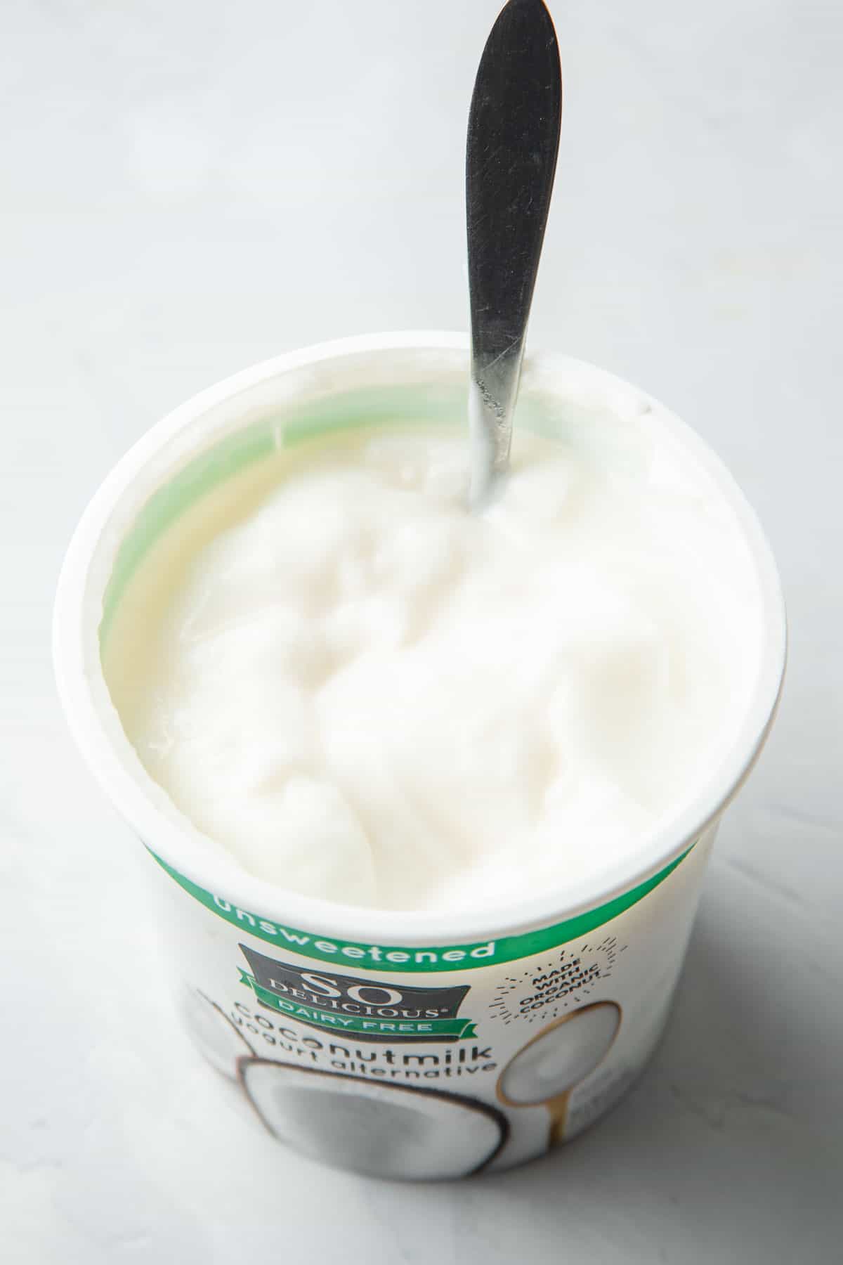 Cup of vegan yogurt with spoon.