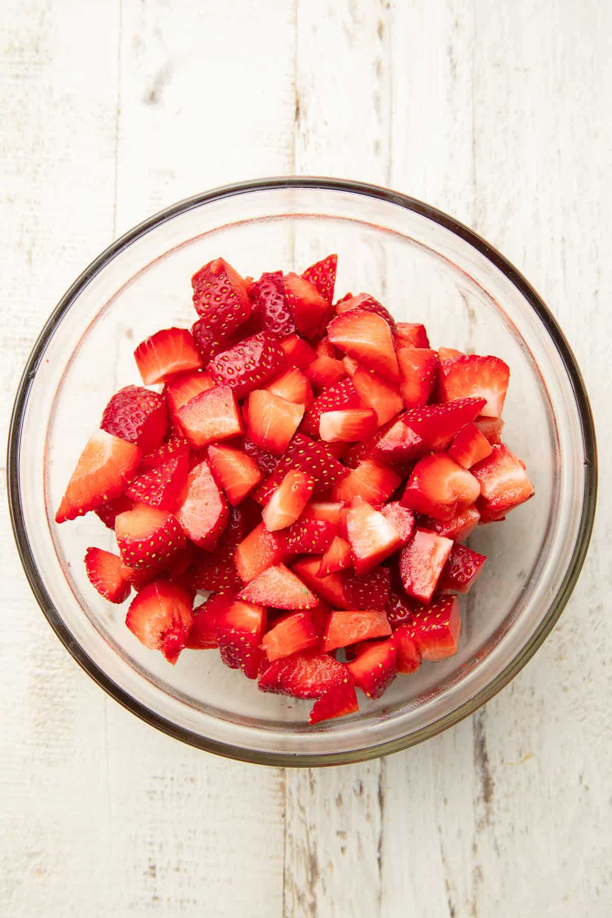 Chopped fresh strawberries in a glass bowl.