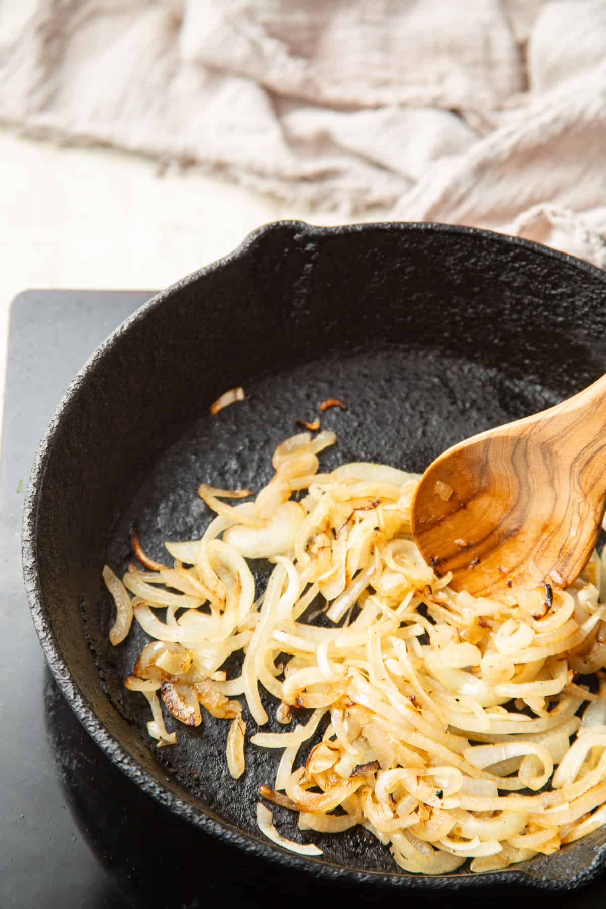 Onion strips browning in a skillet.
