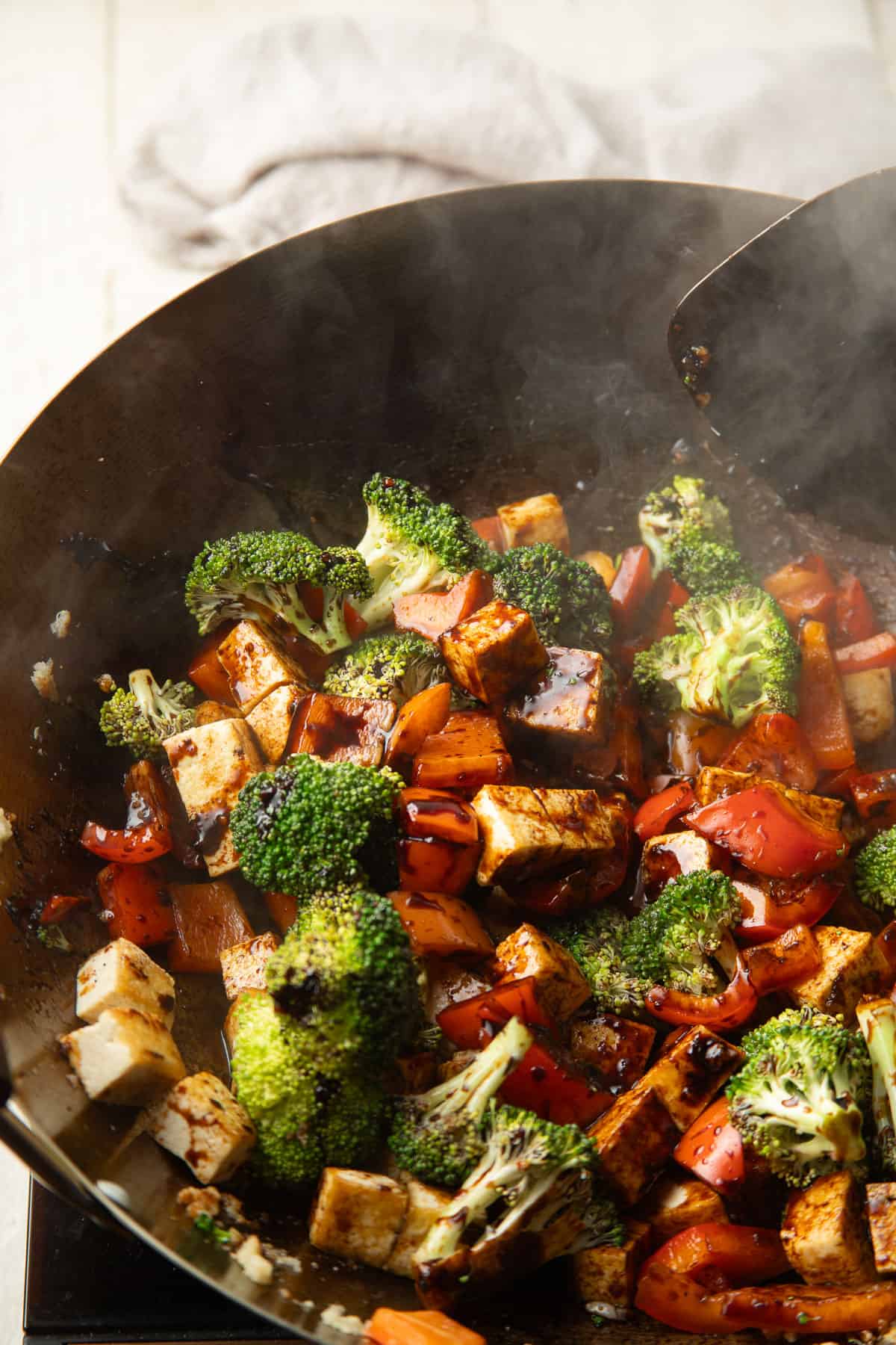 Tofu and veggies stir-frying in a wok.
