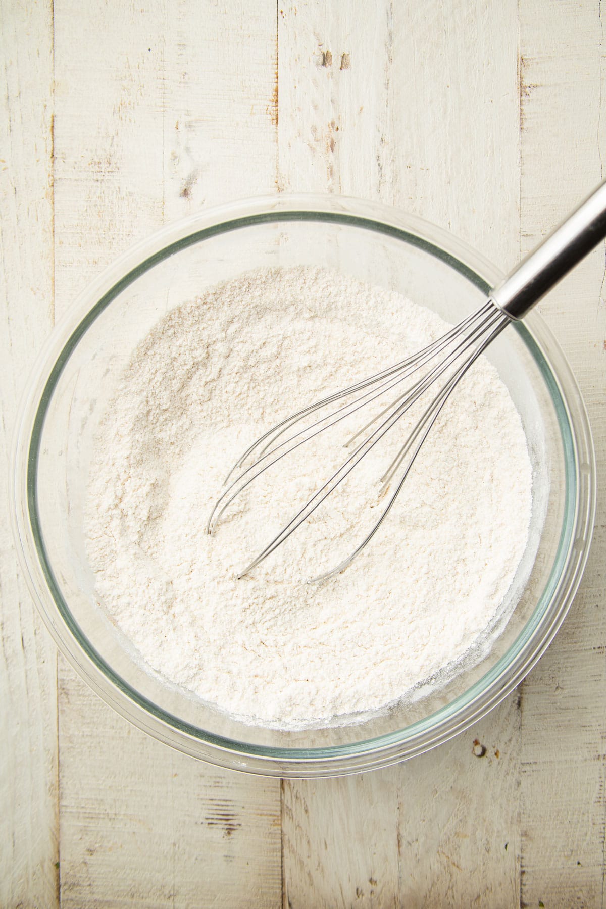 Bowl of dry ingredients for cake batter with whisk.