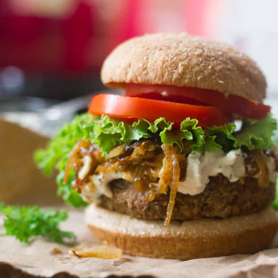 Vegan French onion burger with lettuce and tomato slices.