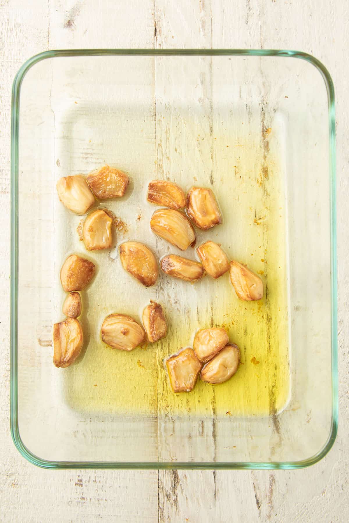 Roasted garlic and olive oil in a glass dish.