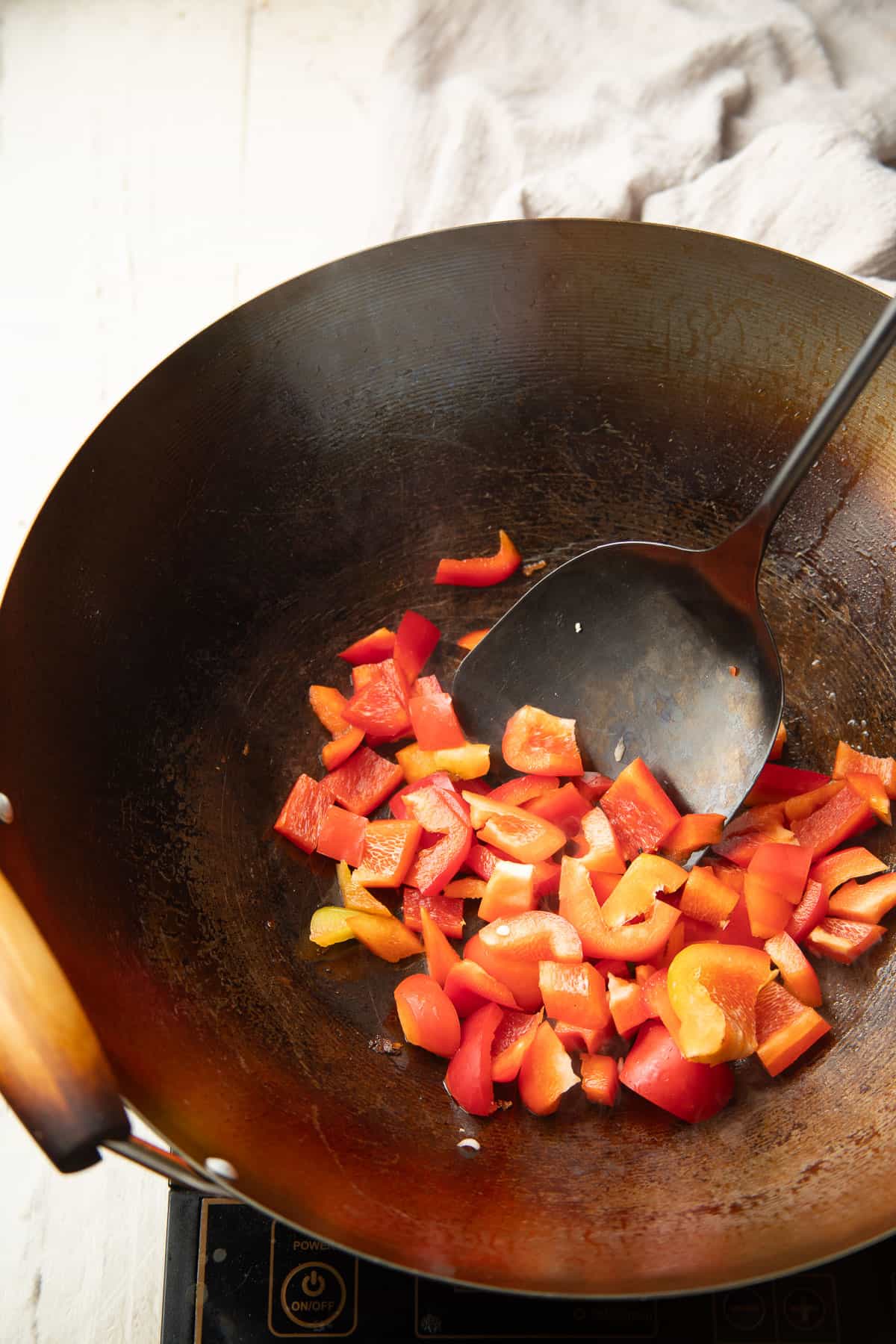 Peppers being stir-fried in a wok.