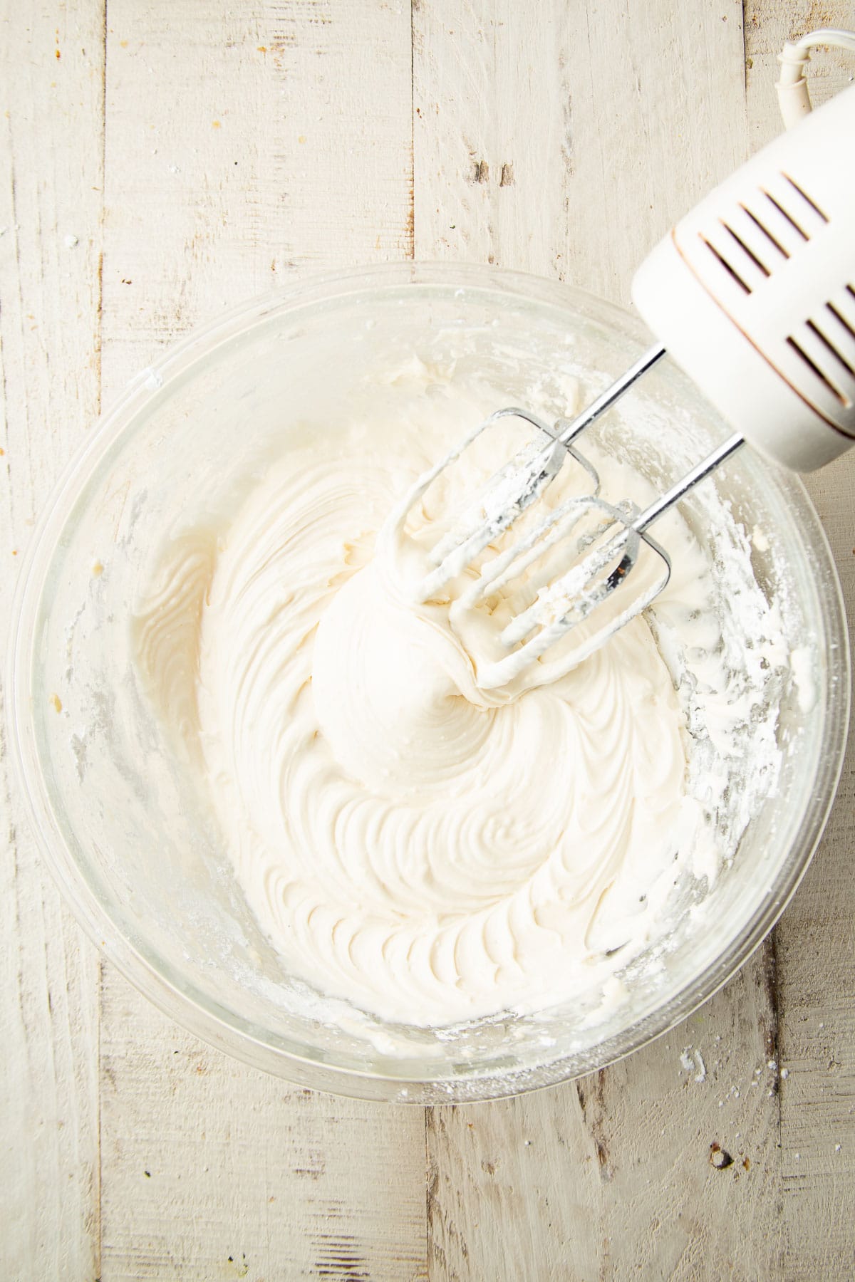 Vegan Cream Cheese Frosting in a mixing bowl with electric mixer.