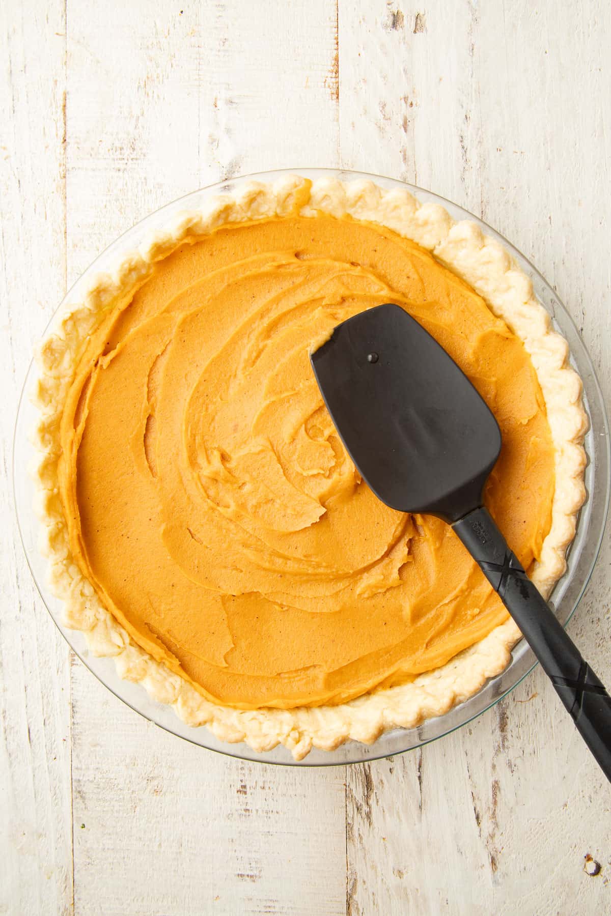 Unbaked Vegan Sweet Potato Pie with a spatula on top.