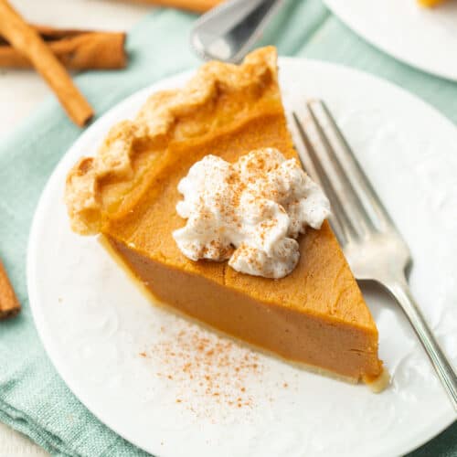 Slice of Vegan Sweet Potato Pie with whipped cream and cinnamon on top.
