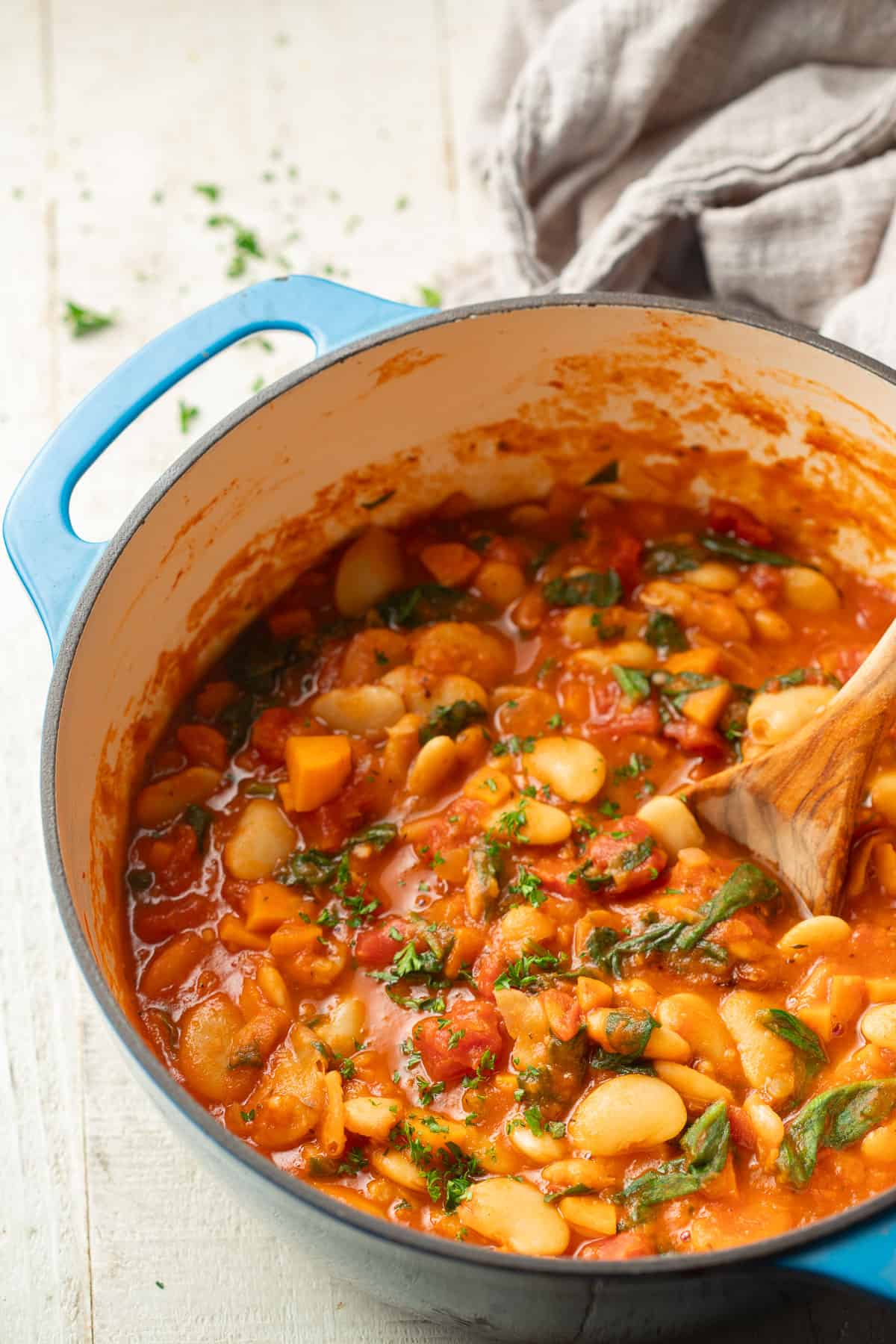 Pot of Butter Bean Stew with a wooden spoon.
